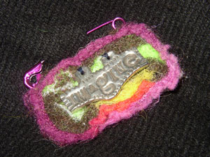 Felted pin that reads "Imagine"