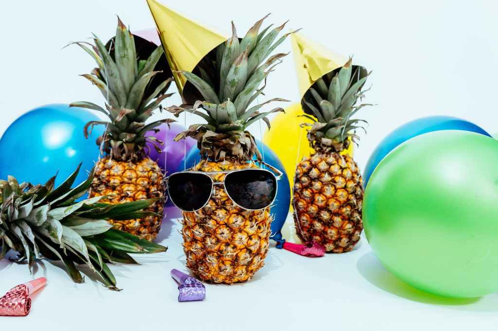 pineapples in birthday hats with balloons