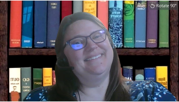 Sonya with a Zoom background of colorful books